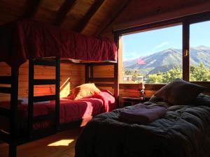 sypialnia z 2 łóżkami piętrowymi i dużym oknem w obiekcie Alojamiento Ruca Wenüy dpto 03 w mieście Bariloche