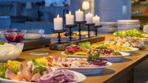 a buffet with plates of food on a table with candles at Austbø Hotell in Rauland