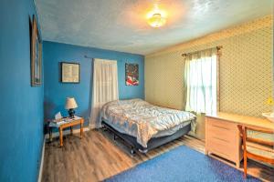 Schlafzimmer mit blauen Wänden, einem Bett und einem Tisch in der Unterkunft Charming Corral Creek Ranch House in Circle in Circle