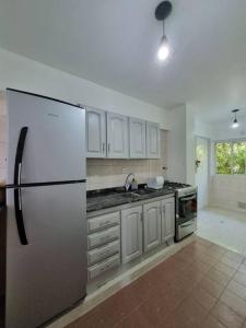 a kitchen with a refrigerator and a sink at Mitre 1400 Apartamentos in Monte Grande