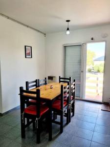 een eetkamer met een houten tafel en stoelen bij Mitre 1400 Apartamentos in Monte Grande