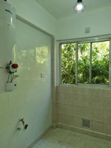 a bathroom with a shower and a window at Mitre 1400 Apartamentos in Monte Grande