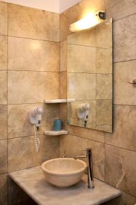 uma casa de banho com um lavatório e um espelho em Louros rooms em Koufonisia