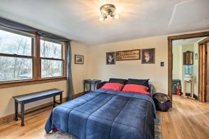 a bedroom with a blue bed with red pillows at Pet-Friendly Bartlett Farmhouse with Deck! in Bartlett
