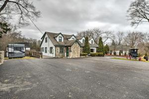 una gran casa blanca con un coche aparcado en la entrada en Pet-Friendly Bartlett Farmhouse with Deck! en Bartlett