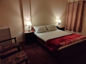 a bedroom with a bed with two lamps on it at Canal view hotel in Faisalabad