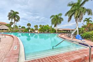a swimming pool at a resort with palm trees at Naples Studio Near Everglades with Marina! in Naples