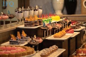 a buffet with many different types of desserts and wine glasses at IFQ Hotel & Resort in Islamabad