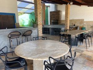a patio with tables and chairs and a bar at Condado da Praia ,casa de temporada em Flecheiras-Ceará in Flecheiras