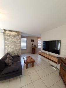 ein Wohnzimmer mit einem Sofa und einem Flachbild-TV in der Unterkunft Comfortable accommodation for 4 people in Toulon