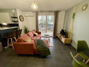 a living room with a couch and a kitchen at La nature aux portes de Toulouse in Pinsaguel