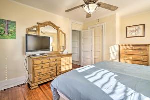 a bedroom with a flat screen tv and a bed at Allenhurst Abode with Porch and Central Location! 