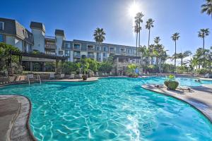 a swimming pool at a resort with palm trees at Deja Blue Beachfront Condo with Resort Pools! in Oceanside