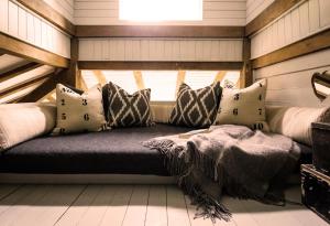 a couch in a room with pillows and a window at Luxury Boltholes cabin in the woods with hot tub 