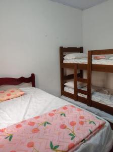 um quarto com 2 camas individuais e 2 beliches em Casa com estacionamento coberto, localizada em Vila Sahy em São Sebastião
