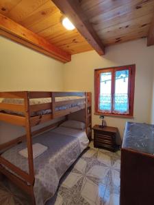 a bedroom with two bunk beds and a window at Agriturismo il fosso in Cutigliano