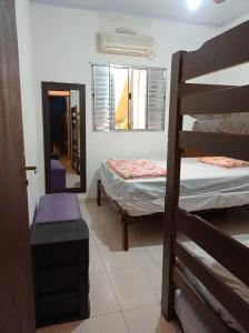 a room with two bunk beds and a mirror at Casa com estacionamento coberto, localizada em Vila Sahy in São Sebastião