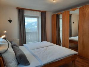 een slaapkamer met een groot bed en een groot raam bij Ferienwohnungen Wimmer in Bischofshofen