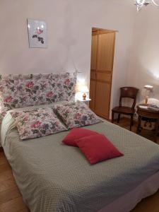 Maison Vérosia في Saint-Loup-de Naud: غرفة نوم عليها سرير ومخدة حمراء
