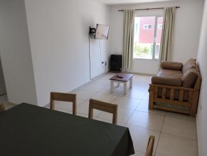 een woonkamer met een bank en een tafel en stoelen bij El Descanso 3 in Tandil
