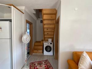 a living room with a washing machine and a staircase at Doğa ile baş başa kalabileceğiniz, sakin kırevi in Rize