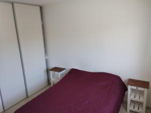 1 dormitorio con cama morada y mesa en El Descanso 3 en Tandil