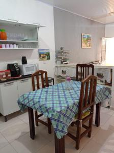 uma cozinha com uma mesa e duas cadeiras e um balcão em Casa com estacionamento coberto, localizada em Vila Sahy em São Sebastião