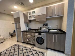a kitchen with a washer and a sink and a dishwasher at Nice cozy studio in Damac Tower Amman 1104 in Amman