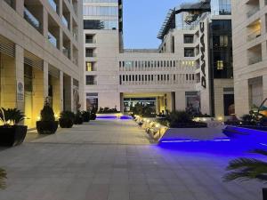 a large building with blue lights in a courtyard at Nice cozy studio in Damac Tower Amman 1104 in Amman