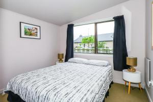 1 dormitorio con cama y ventana en Methven Ski Bach With Sleepout en Methven