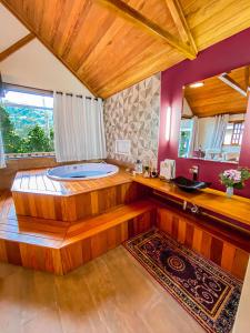 uma grande casa de banho com banheira num quarto em Chalés Princesa Isabel em Petrópolis