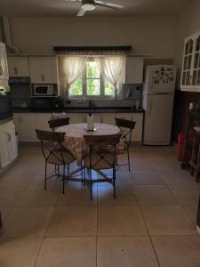 een keuken met een tafel en stoelen en een koelkast bij Posada de Emilia in Albardón