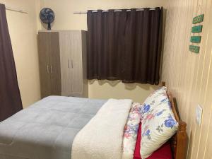 a small bedroom with a bed and a window at Apartamento para casal in Cambara do Sul