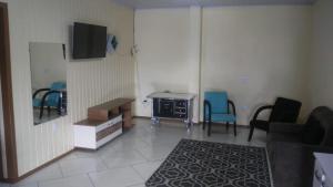 a room with a room with chairs and a desk at Apartamento para casal in Cambara do Sul