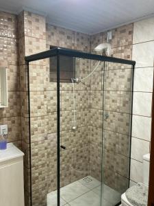 a shower with a glass door in a bathroom at Apartamento para casal in Cambara do Sul
