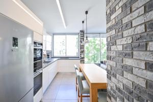 eine Küche und ein Esszimmer mit Ziegelwand in der Unterkunft Vernal By HolyGuest in Tel Aviv
