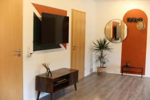 a living room with a television on a wall at Haoma Lodge Oase I Superzentral I Free Parking I WLAN I Netflix in Erlangen