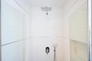 eine Dusche im Bad mit weißen Wänden in der Unterkunft Vernal By HolyGuest in Tel Aviv