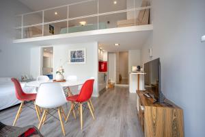 uma sala de estar com uma mesa e cadeiras e uma televisão em Oporto Trendy Apartments no Porto