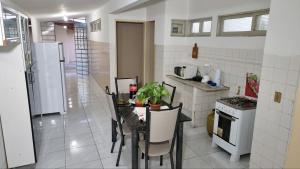 a kitchen with a table with chairs and a refrigerator at RECANTO DO LUAR in Piranhas