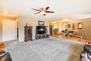 a living room with a ceiling fan and a flat screen tv at Hillside Anchorage Home by Hiking and Biking Trails! in Anchorage