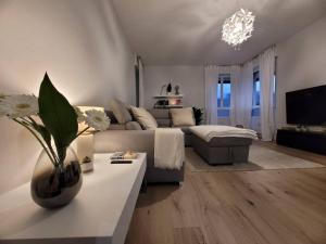 sala de estar con sofá y mesa con flores en View lovely 3bed-2bath condo full furnished., en Vittorio Veneto
