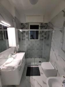 Baño blanco con 2 lavabos y aseo en View lovely 3bed-2bath condo full furnished., en Vittorio Veneto