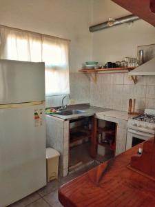 a kitchen with a refrigerator and a sink at Alojamiento Casa en El Bolsón in El Bolsón