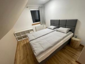 伊斯泰布納的住宿－Dom Pod Świerkami，卧室配有一张带白色床单的大床和窗户。
