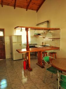 a kitchen with a wooden table and a refrigerator at Alojamiento Casa en El Bolsón in El Bolsón