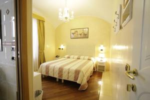 a bedroom with a bed and a chandelier at Hotel Vienna Ostenda e Ristorante il Danubio in Rimini