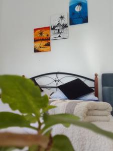 une chambre avec un lit avec trois tableaux au mur dans l'établissement Ocean Surf Lodge, à Taghazout