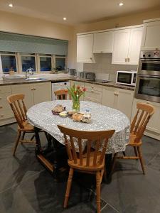 a kitchen with a table with chairs and a counter top at Pandy Barn Berriew in Welshpool