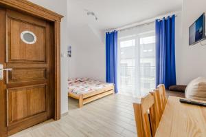 Zimmer mit einer Tür, einem Bett und einem Tisch in der Unterkunft Willa Artus in Władysławowo